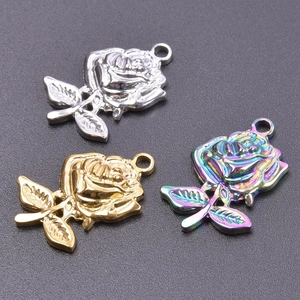 Detailed macro view of three rose-shaped metal pendants in silver, gold, and rainbow colors