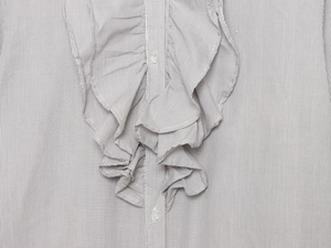 Detail of grey striped shirt featuring ruffle decorative trim and white button-down closure
