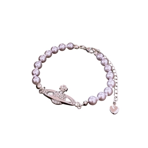Elegant silver pearl bracelet featuring a sparkling crystal-encrusted Saturn charm and heart