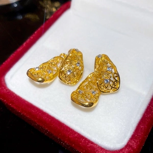 Gros plan de boucles d'oreilles filigranes dorées avec cristaux en boîte rouge