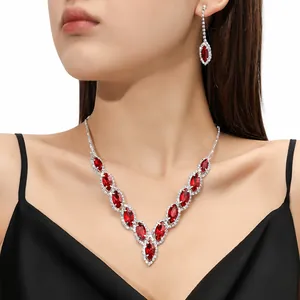 Detail of elegant V-shaped necklace and drop earrings with red crystals on a model