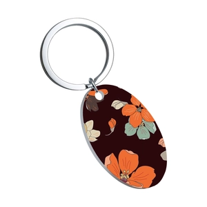 Detail of oval stainless steel pendant with orange and light blue floral patterns