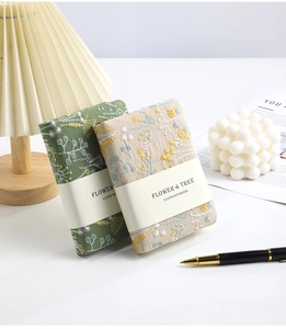 Close-up of A6 linen notebooks featuring elegant flower and tree floral embroidery textures