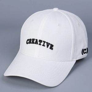 Macro shot of white baseball cap featuring black 'CREATIVE' letter embroidery and stitch detail