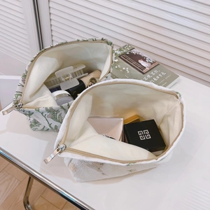 Floral embroidered makeup bags in green and beige with zipper closure for travel storage