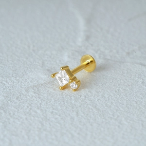 Macro shot of gold-plated flat back cartilage stud with square and round clear crystals