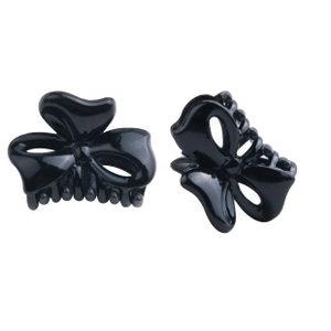 Close-up of two small black bow-shaped plastic hair claw clips with fine teeth details