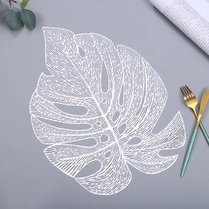 Detail of white monstera leaf placemat with hollow design and elegant table setting