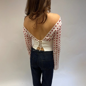 Détail du haut en mousseline à pois blancs avec un design dos nu sexy et taille nouée