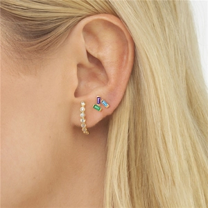 Macro detail of gold-plated silver stud earrings set with colorful marquise zircons