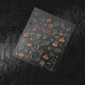 Halloween nail art stickers with gold pumpkin, ghost, and bat patterns on black background