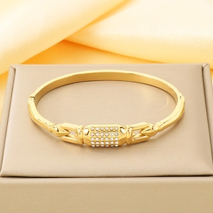 Détail de bracelet jonc en acier inoxydable plaqué or 18k avec pavé de cristaux brillants