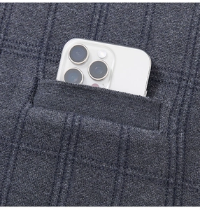 Macro detail of deep grey knit vest pocket showing fine sewing and smartphone capacity