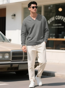 Close-up of charcoal grey V-neck knit sweater showing intricate jacquard texture and ribbing