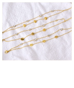 Detailed close-up of gold titanium steel bracelets with heart and evil eye charms