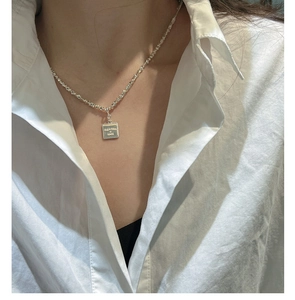 Close-up of S925 silver necklace with crushed silver chain and square engraved pendant