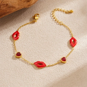 Detail of gold chain bracelet with red enamel lips and heart-shaped zirconia charms