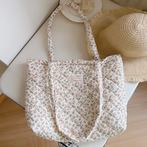 Detail of pink floral quilted tote bag with soft padding and French woven label on front