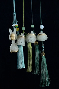 Detailed view of hollow luminous stone sachets with silk tassels in vintage Chinese style