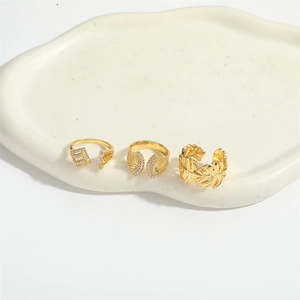 Three-piece set of golden adjustable rings with zircon accents and hollow leaf motifs