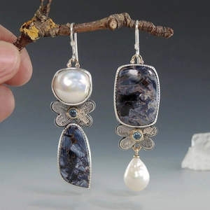 Boucles d'oreilles pendantes asymétriques avec pierre verte et détails floraux argent