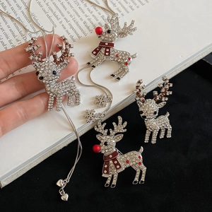 Detail shot of Christmas reindeer jewelry set with sparkling rhinestones on book background