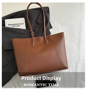 Detail of vintage brown leather tote bag showing high-quality stitching on white fabric background