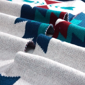 Close-up of geometric star pattern knitting with navy blue and burgundy yarn textures