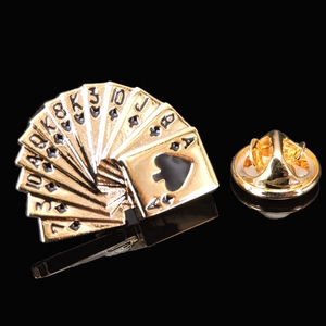 Detailed view of fan-shaped golden playing card brooch with black spade enamel inlay