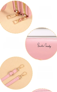 Detail of pink PU leather bag featuring gold zippers, brand logo and detachable strap