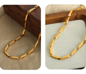 Macro shot of gold geometric bamboo chain links with fine engraved patterns on the necklace