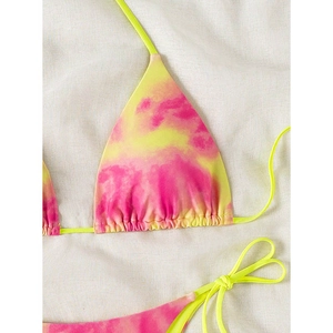 Detail of neon tie-dye bikini set with lace-up straps and ruffled edges on linen