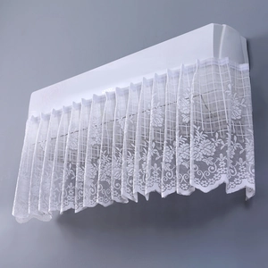 Close-up of white floral lace dust cover showing detailed texture on a wall AC unit