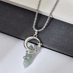 Detail of green hexagonal crystal pendant wrapped in silver moon and star metal frame