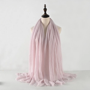 Detailed texture of light pink pleated cotton linen scarf with raw fringe edges