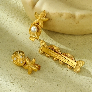 Goldene Haarspangen mit Meeresmotiven Seestern Muschel und Perle auf Sandgrund
