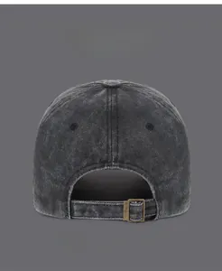 Detail view of washed denim baseball cap with an adjustable bronze metal buckle