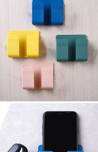 Detail of colorful wall-mounted storage organizers showing phone and watch holders