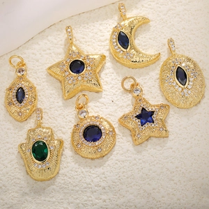 Detailed macro view of 18k gold-plated charms with blue and green crystals