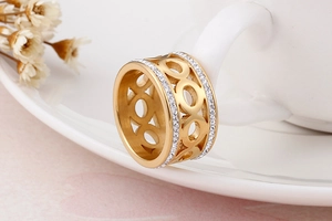 Close-up of golden stainless steel ring with hollow circles and double row zircon stones