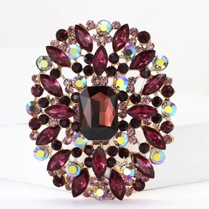 Macro shot of large alloy brooch with sparkling purple and iridescent crystals on gold base