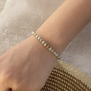 Close-up of vintage beaded bracelet with natural stones and golden spacer beads on wrist