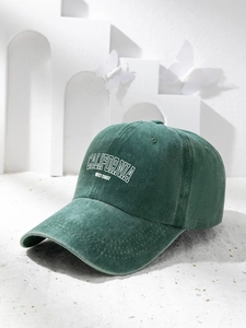 Detailed close-up of dark green washed cotton baseball cap with white CALIFORNIA embroidery