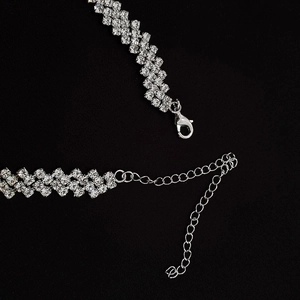Macro shot of silver rhinestone necklace featuring a secure lobster clasp and extension chain