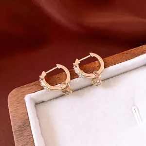 Boucles d'oreilles créoles fleurs en zircon doré avec trèfle sur boîte en velours