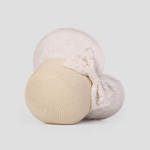 Close-up of fine straw texture and large bow detail on a stylish beige sun hat