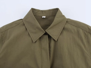 Detailed view of olive green shirt collar with pocket accents and woven fabric texture