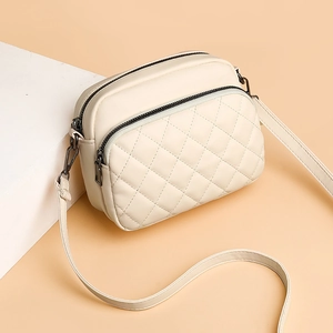Chic beige quilted crossbody bag with metal zippers and adjustable long shoulder strap