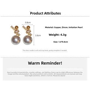 Detail view of gold geometric earrings with sparkling zircon stones and white faux pearls