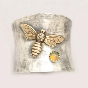 Wide silver hammered band ring featuring a gold bee motif and amber stone accent